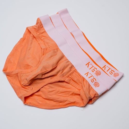 Orange underwear with a pink towel featuring 'KTE' branding on a light gray background
